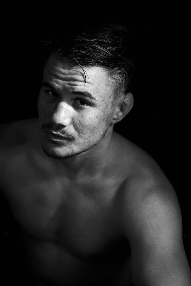 A black and white photo of a shirtless man.