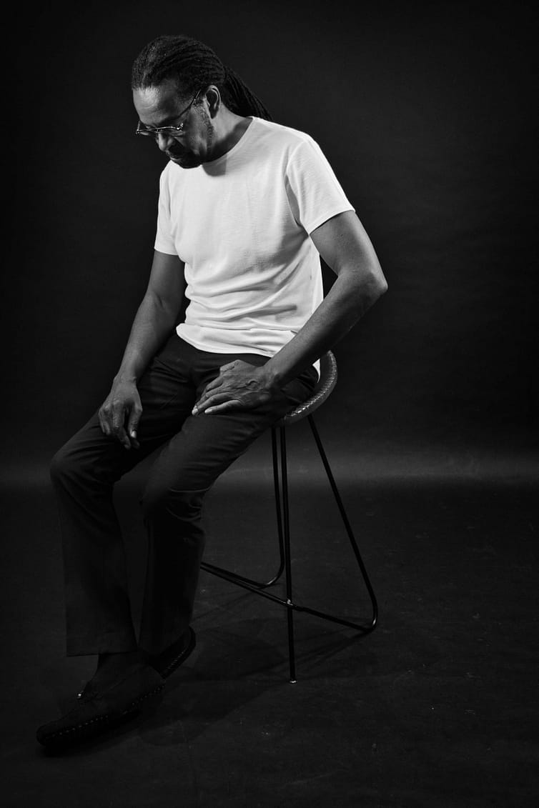 A black and white photo of a man sitting on a chair.